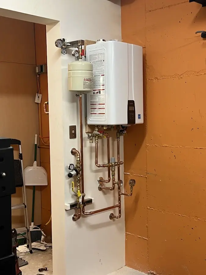 Plumbing technician inspecting water heater connections in Surf City